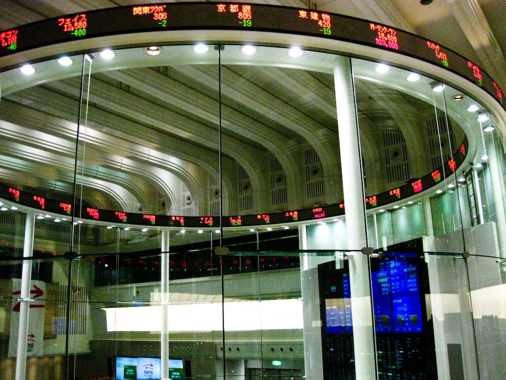 Multiple stock market trading screens displaying charts, prices and financial data in a trading room.